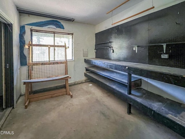 basement with a textured ceiling and a workshop area