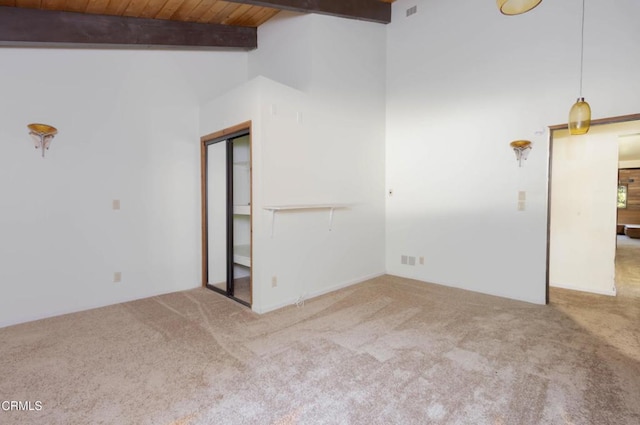 spare room featuring beamed ceiling, light colored carpet, wooden ceiling, and high vaulted ceiling