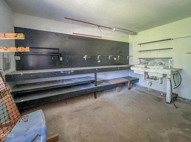 basement with a textured ceiling and a workshop area