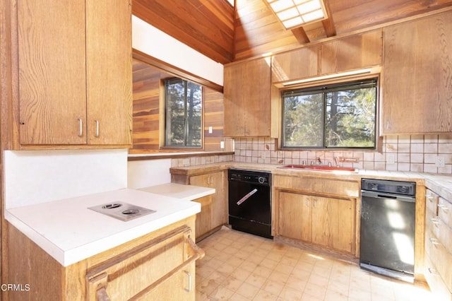 kitchen with decorative backsplash, dishwasher, wooden walls, and sink