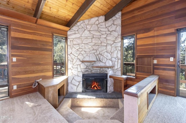 carpeted living room featuring a wealth of natural light, a fireplace, and wooden walls