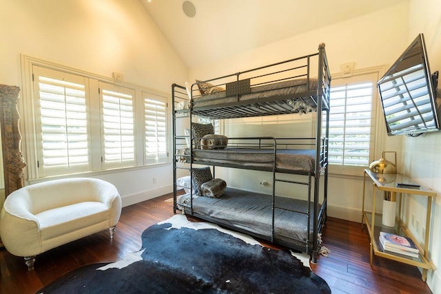 bedroom with multiple windows, high vaulted ceiling, and dark hardwood / wood-style floors