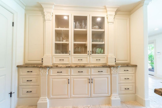 bar with white cabinetry, light stone countertops, light tile patterned floors, and ornamental molding