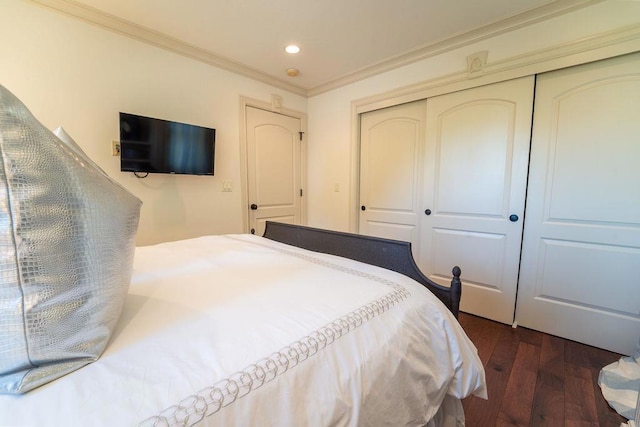 bedroom featuring ornamental molding, a closet, and dark wood-type flooring