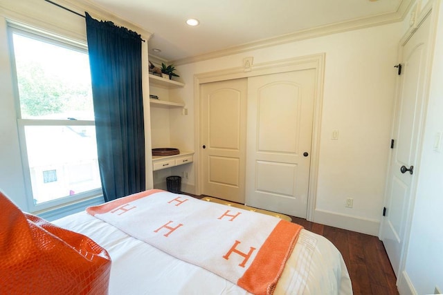 bedroom with dark hardwood / wood-style flooring, a closet, and crown molding