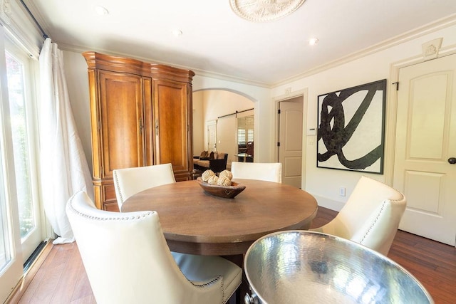 dining space with light hardwood / wood-style floors and crown molding