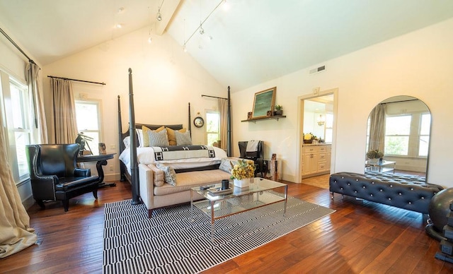 bedroom with beamed ceiling, wood-type flooring, connected bathroom, and high vaulted ceiling