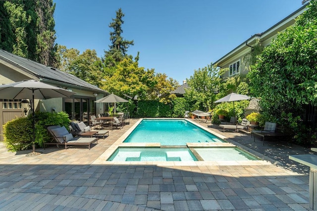 view of pool with an in ground hot tub and a patio area