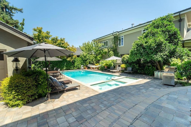 view of pool featuring area for grilling, an in ground hot tub, and a patio