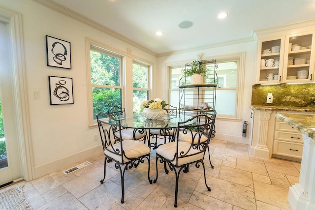 dining space featuring crown molding