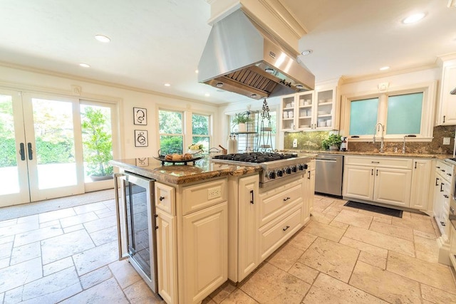 kitchen with wine cooler, a kitchen island, tasteful backsplash, island range hood, and stainless steel appliances