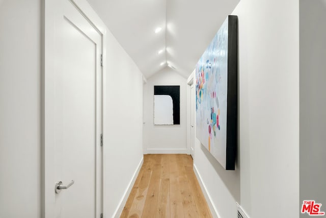 corridor featuring lofted ceiling and light wood-type flooring