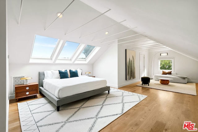 bedroom with hardwood / wood-style flooring and lofted ceiling