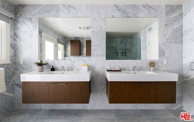 bathroom featuring vanity, a shower with door, and tile walls