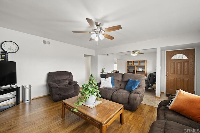 living room featuring light hardwood / wood-style floors and ceiling fan