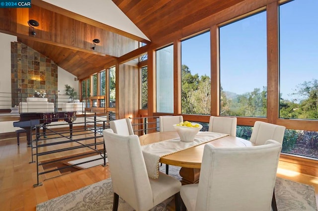 sunroom / solarium featuring lofted ceiling, wooden ceiling, and a healthy amount of sunlight