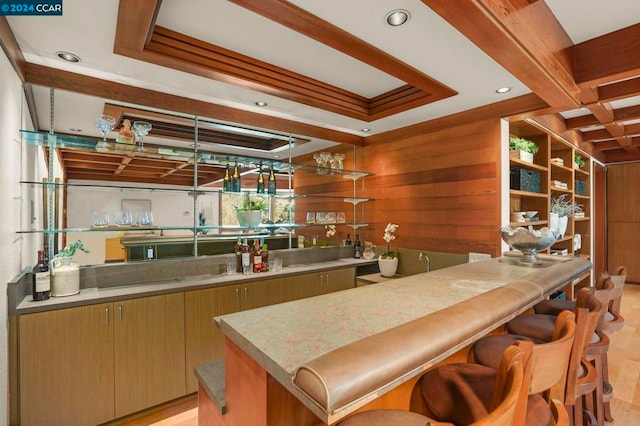 bar with wooden walls, light hardwood / wood-style flooring, and beamed ceiling