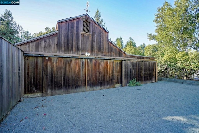 view of side of home featuring an outbuilding