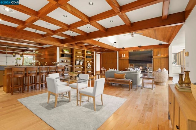 dining space with ceiling fan, beam ceiling, light wood-type flooring, and coffered ceiling