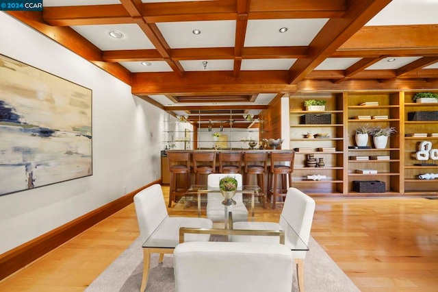 dining area featuring beam ceiling, wood-type flooring, and coffered ceiling