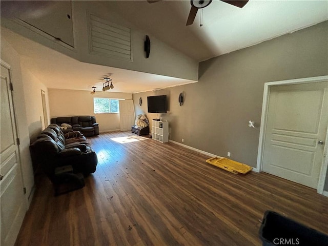 living room featuring dark hardwood / wood-style floors, ceiling fan, and vaulted ceiling