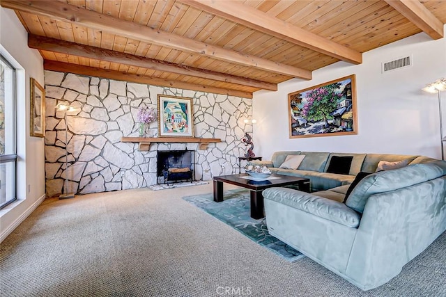 carpeted living room featuring a fireplace, beamed ceiling, and wood ceiling