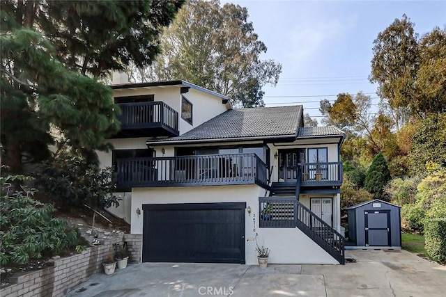 view of front of property with a balcony, a shed, and a garage