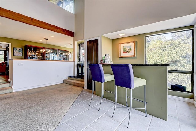 interior space featuring a wealth of natural light, a towering ceiling, and light carpet