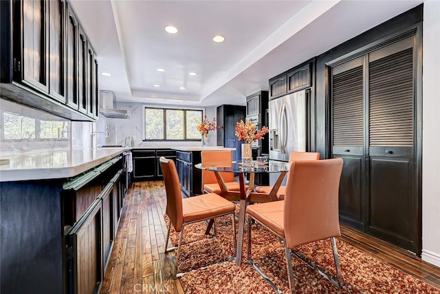 dining room featuring a tray ceiling and dark wood-type flooring