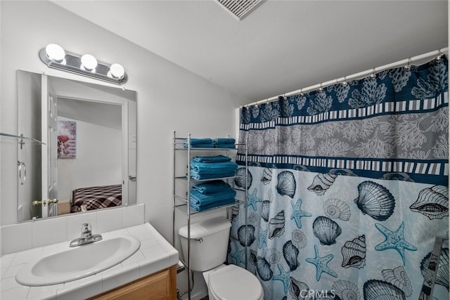 bathroom with toilet, vanity, and a shower with shower curtain