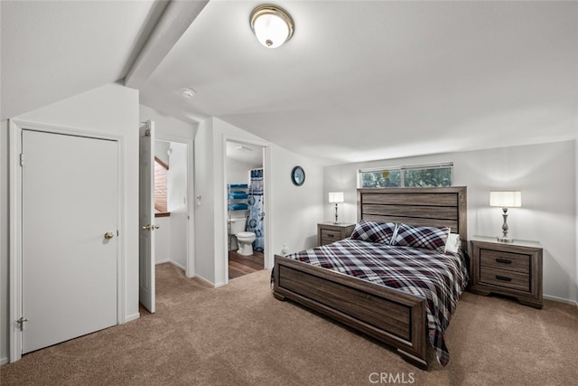 carpeted bedroom featuring lofted ceiling and ensuite bathroom