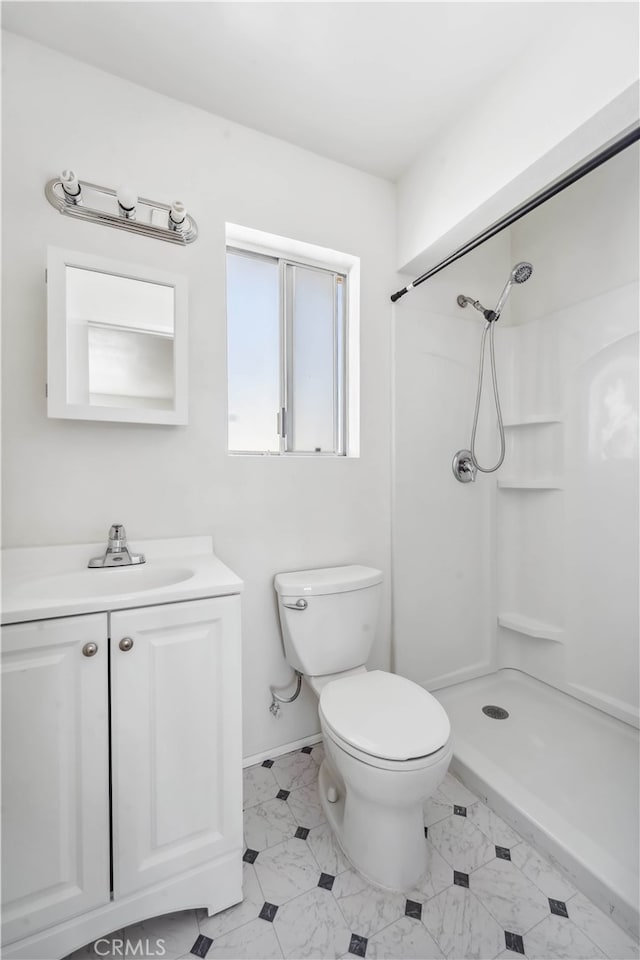 bathroom with a shower, vanity, and toilet