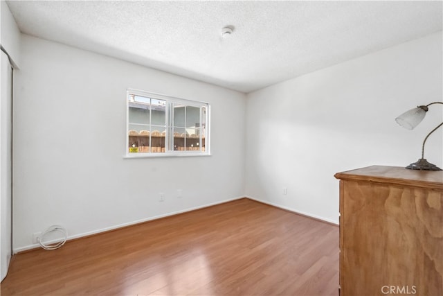 empty room featuring hardwood / wood-style flooring and a textured ceiling