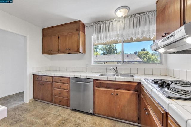 kitchen with tile countertops, gas stovetop, a wealth of natural light, stainless steel dishwasher, and sink