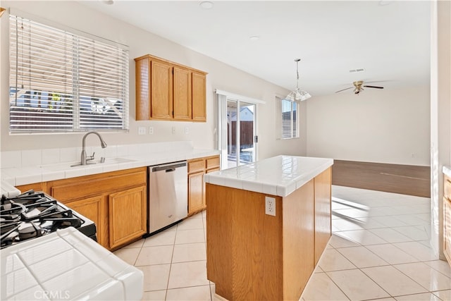 kitchen with a kitchen island, sink, pendant lighting, tile countertops, and dishwasher