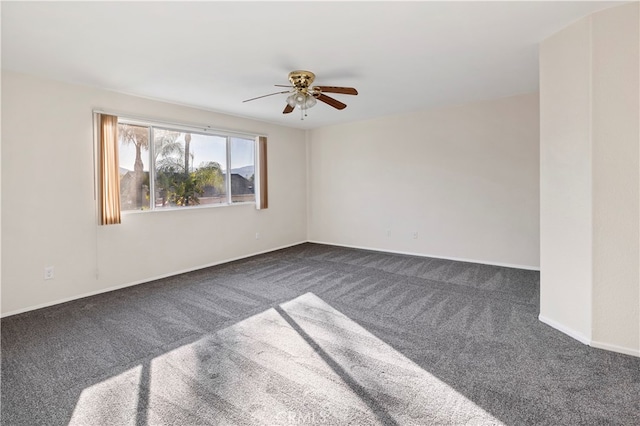 unfurnished room with dark colored carpet and ceiling fan