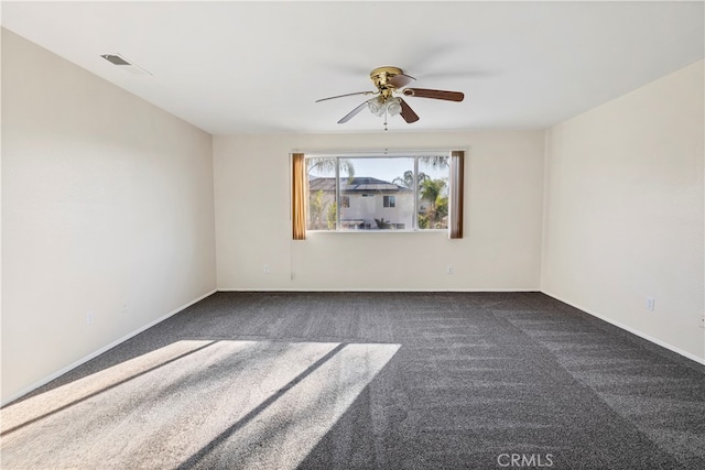 empty room featuring dark carpet and ceiling fan