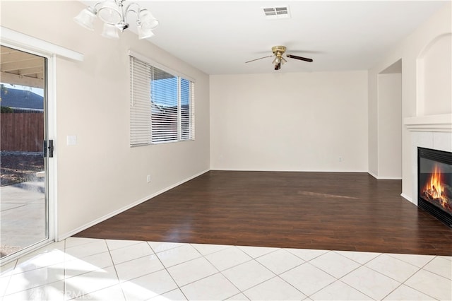 unfurnished living room with a fireplace, a wealth of natural light, and light wood-type flooring