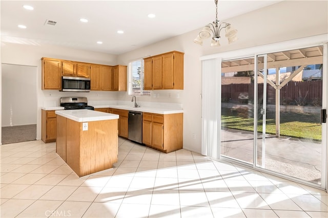 kitchen with hanging light fixtures, light tile patterned floors, a kitchen island, a chandelier, and stainless steel appliances