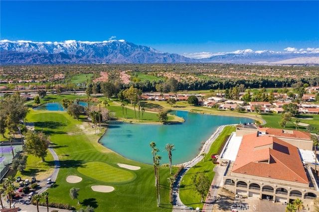 drone / aerial view featuring golf course view and a water and mountain view