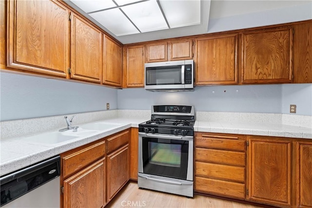 kitchen featuring stainless steel appliances, sink, and light hardwood / wood-style floors