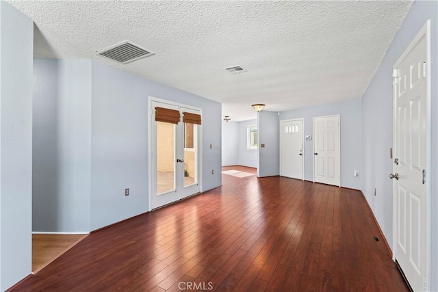 unfurnished room with dark wood-type flooring and a textured ceiling