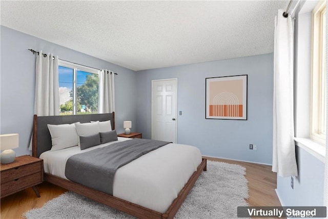 bedroom featuring light hardwood / wood-style floors and a textured ceiling