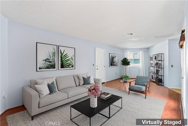 living room with hardwood / wood-style floors and a textured ceiling