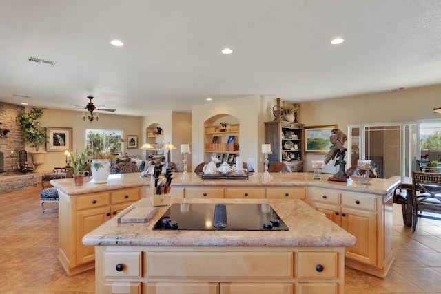 kitchen featuring a wealth of natural light, black electric cooktop, and a center island