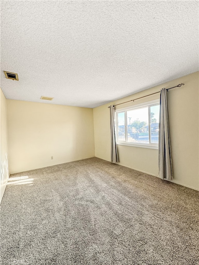 carpeted spare room featuring a textured ceiling