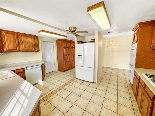 kitchen featuring ceiling fan with notable chandelier, decorative light fixtures, light tile patterned floors, and white appliances