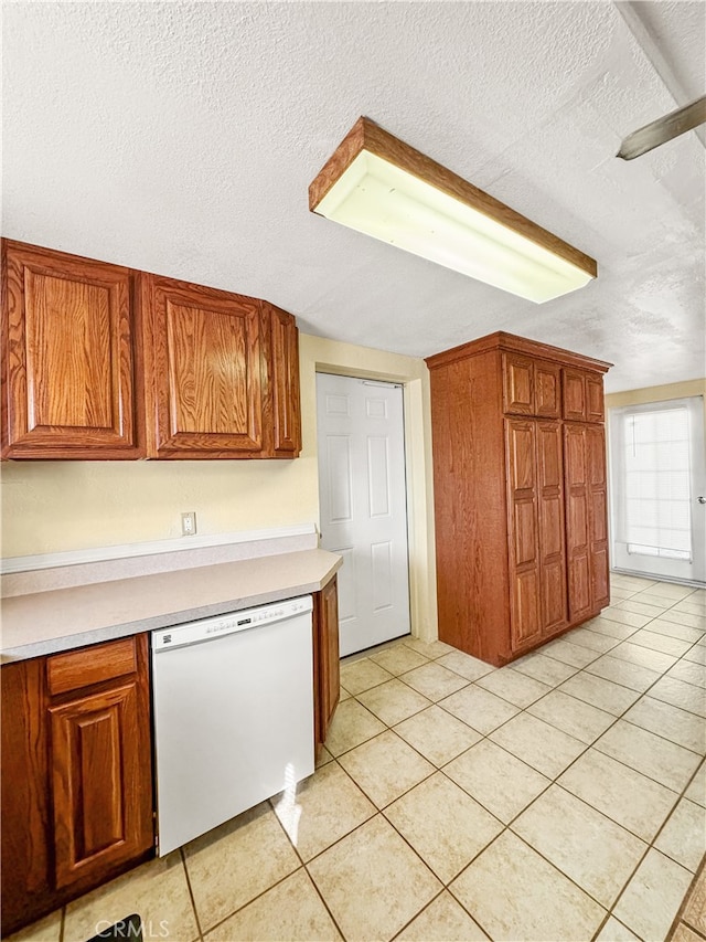 kitchen with dishwasher, light tile patterned floors, and a textured ceiling