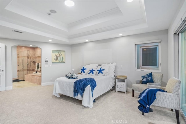 bedroom with a tray ceiling, crown molding, ensuite bathroom, and carpet floors