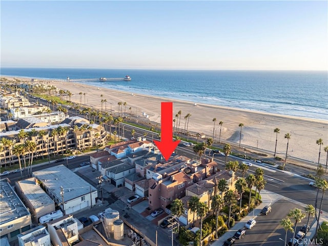 birds eye view of property with a water view and a beach view